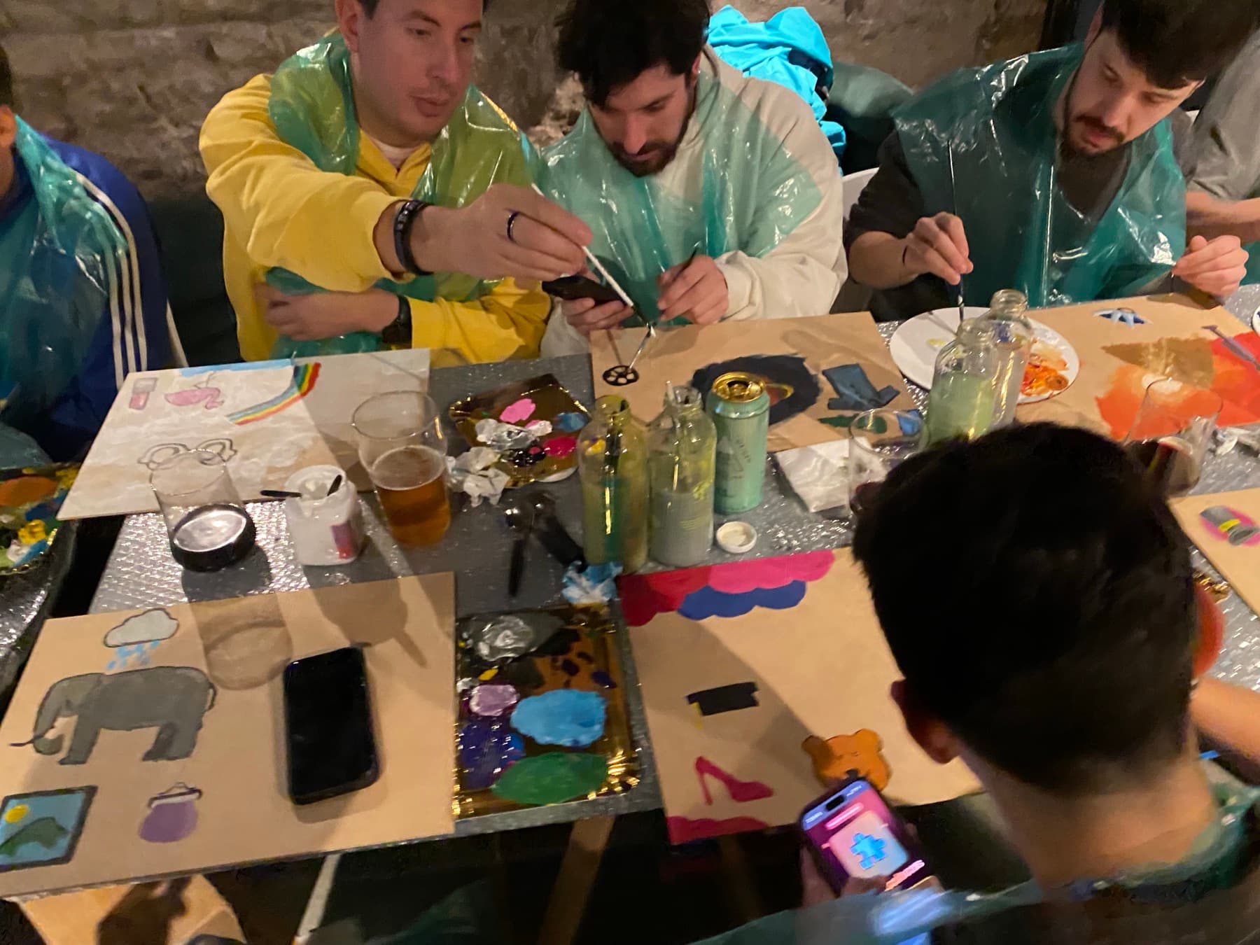 Mesa con lienzos, pinturas y vasos en Vino y Pintura Night